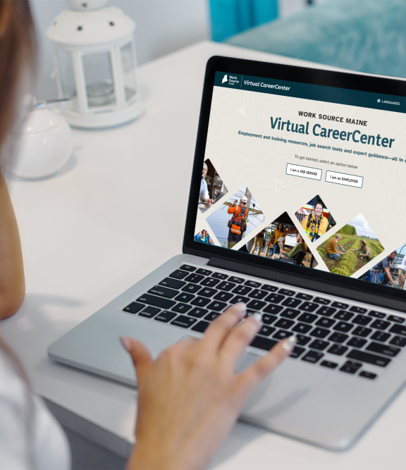 Person using laptop to view Work Source Maine Virtual CareerCenter homepage with job seeker and employer options