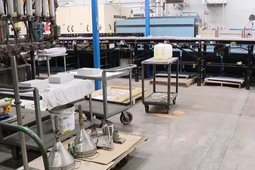 A manufacturing room with a conveyor belt and carts for producing metal products
