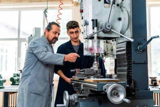 Instructor teaching student on industrial machinery 