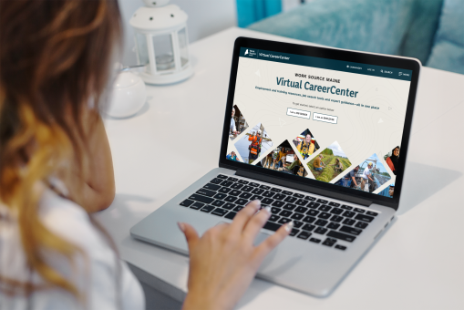 Person using laptop to view Work Source Maine Virtual CareerCenter homepage with job seeker and employer options